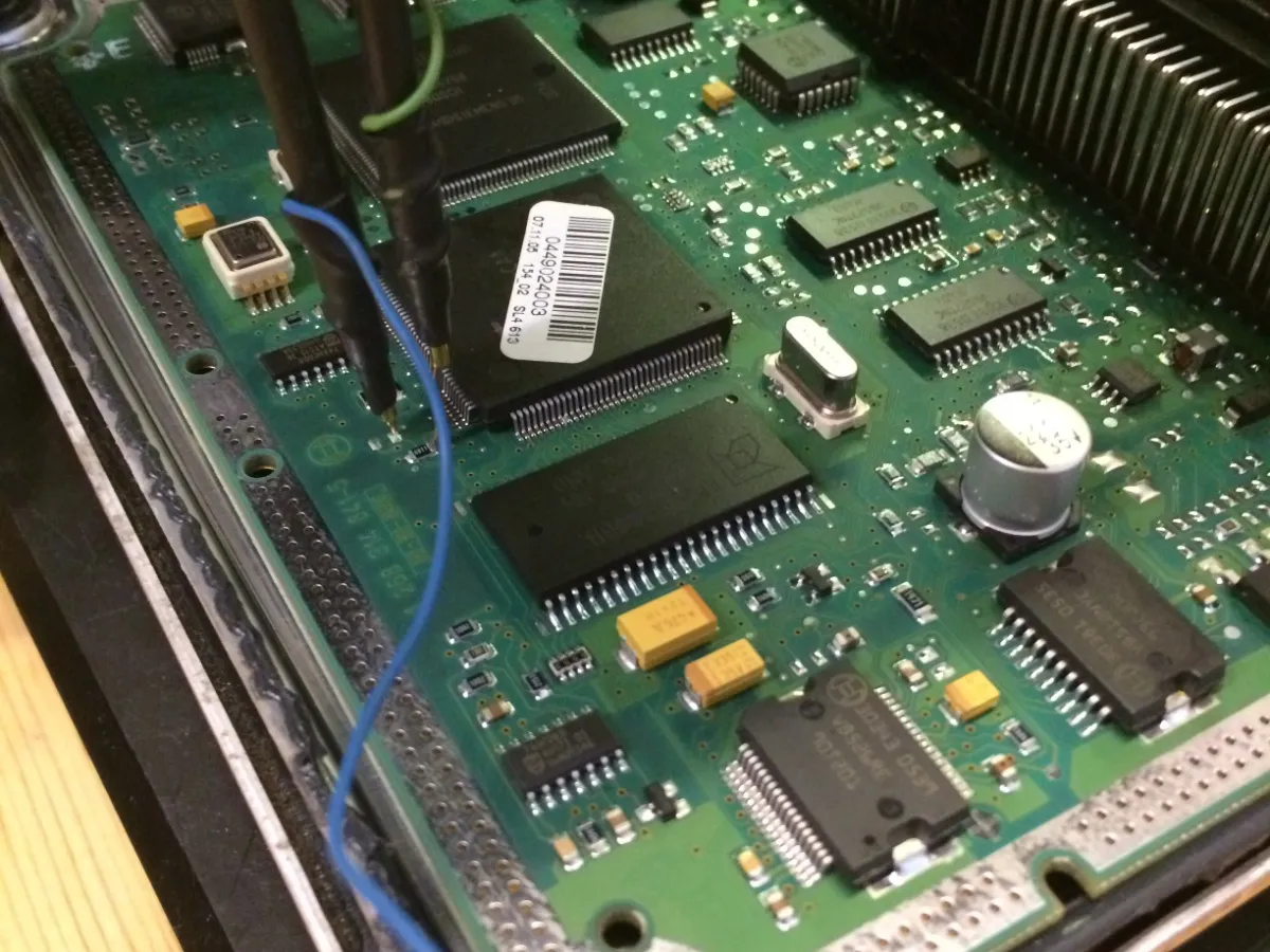 Öppen ECU på arbetsbänk under arbete med motoroptimering.